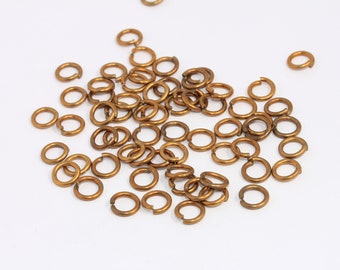 May include: A pile of gold jump rings, a type of jewelry finding used for connecting chains, cords, and other jewelry components.