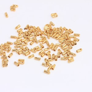 Könnte beinhalten: Ein Haufen goldfarbener Metall-Endkappen für Schnüre oder Schmuckherstellung.