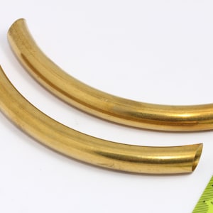 May include: Two gold-colored metal hoops, each with a slightly different curve. The hoops are about 6 inches in diameter and are shown next to a ruler.