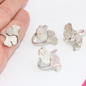May include: Four silver rings with a ginkgo leaf design. The rings are adjustable and can be worn on any finger.