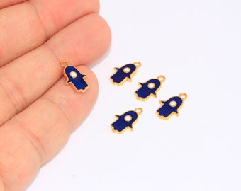 May include: Five gold-colored Hamsa hand charms with blue enamel and a white center. The charms have a loop at the top for attaching to jewelry or other crafts.