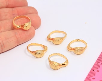 May include: Four gold-colored rings with a textured surface. The rings are open and adjustable.