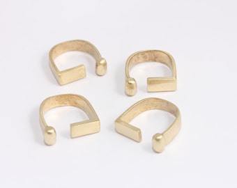 Puede incluir: Cuatro anillos de metal de color dorado con un diseño abierto único. Cada anillo tiene un extremo redondeado y una barra rectangular plana.