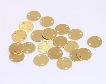 May include: A collection of 18 gold-toned metal round discs with two holes each. The discs are smooth and have a brushed finish.