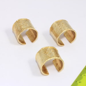 Puede incluir: Tres anillos de metal dorado con textura martillada. Los anillos son abiertos y se pueden ajustar para adaptarse a diferentes tamaños de dedos.