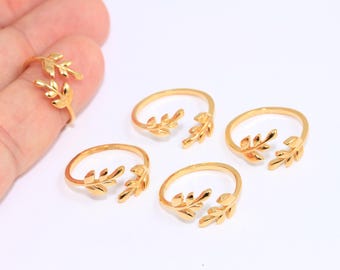 Könnte beinhalten: Vier goldfarbene Ringe mit einem Blattdesign. Die Ringe sind offen und verstellbar.