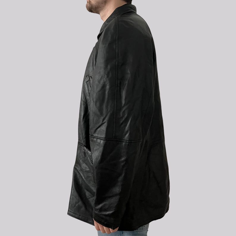 May include: A black leather jacket with a collared neckline and a button-down front. The jacket has a classic design with a tailored fit and a pocket on the chest. The jacket is made of a smooth, shiny leather material.