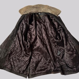 May include: Open view of a dark brown leather jacket with a tan fur collar and a quilted brown satin lining. The jacket is unbuttoned, revealing the interior details. The label reads "Leather Soul".