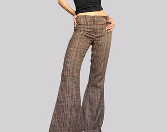 May include: Brown and black plaid flared pants. The pants have a high waist and a wide leg opening. The fabric has a subtle sheen. The pants are a vintage style.