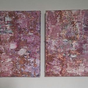 Könnte beinhalten: Zwei abstrakte Gemälde auf Leinwand in einem Farbton von Rosa, Lila und Gold. Die Gemälde haben eine strukturierte, geschichtete Optik.