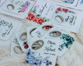 Puede incluir: Conjunto de abridores de botellas cuadrados blancos con diseños florales y el texto "Olivia & Michael" y "August 15, 2024".