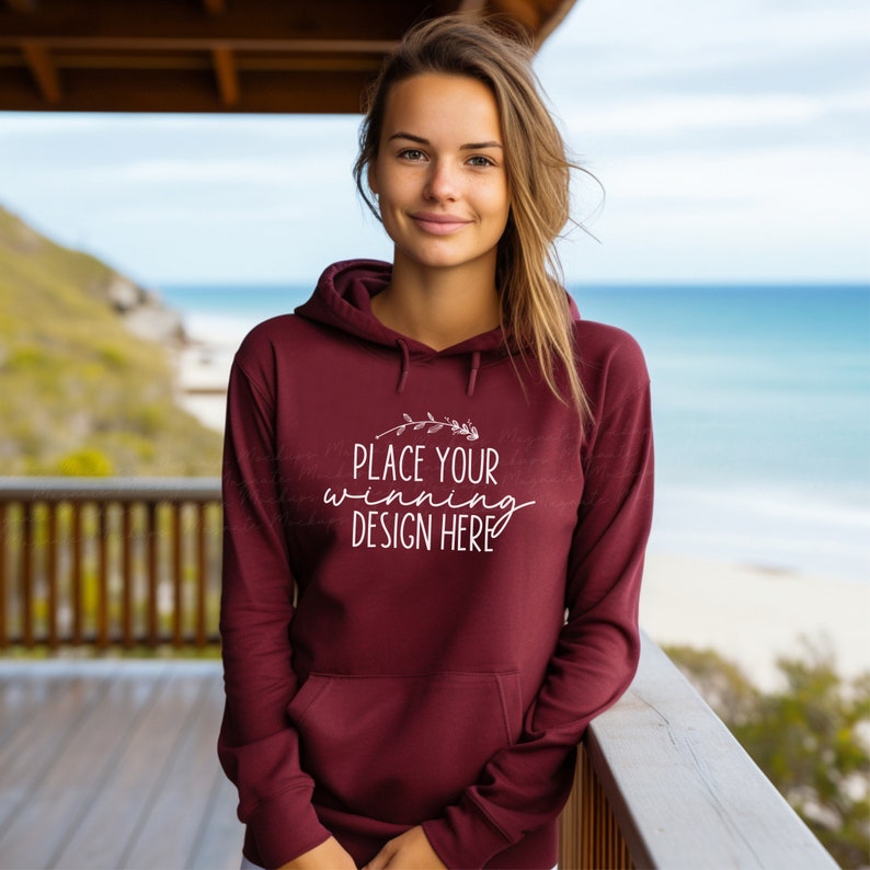 May include: A maroon hoodie with a white design that says "Place your winning design here" with a small floral graphic above the text.