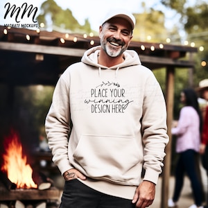 May include: A beige hoodie with a black floral design and the text "Place your winning design here". The hoodie is being worn by a person outdoors.