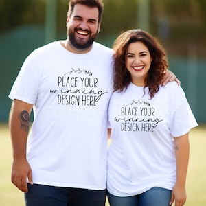 May include: Two white t-shirts with the text "Place your winning design here" and a small floral design. The shirts are being worn by two people.