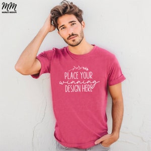May include: A man wearing a pink t-shirt with the text "Place your winning design here" in white. The shirt has a floral design above the text.