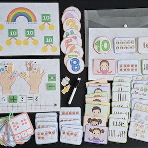 May include: A set of colourful educational flashcards for teaching counting and number recognition. The cards feature numbers, tally marks, and pictures of objects. The set also includes a number line, a rainbow, and a hand with finger puppets.