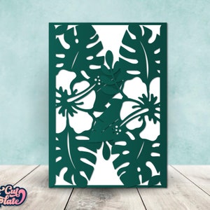 May include: A digital cut file design featuring tropical flowers and leaves. The design is in a dark green color and is perfect for creating cards, invitations, or other paper crafts.