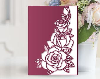 May include: A burgundy card with a white outline of a floral design featuring roses and leaves. The card is 5 inches by 7 inches and is designed for use with a Cricut, Cameo, or laser cutter.