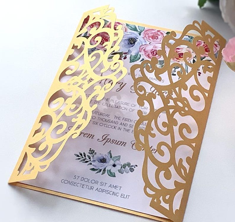 May include: Gold laser cut wedding invitation with a floral design and the text "The pleasure of your presence is requested for the celebration of... Saturday, the fifth of June, two thousand and seventeen, at six o'clock in the evening... Lorem Ipsum... 37 Dolor Sit Amet Consectetur Adipiscing Elit"