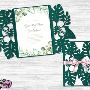 May include: A green and white wedding invitation with a tropical leaf design. The invitation is folded in half and has a white envelope with a pink ribbon.