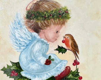 May include: An oil painting of a small angel with light brown hair, a green holly wreath, and a thin halo, wearing a pale blue gown. The angel sits on green holly leaves with red berries, facing a small brown robin holding a red berry.