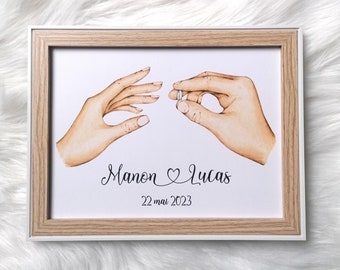 May include: A framed illustration of two hands, one holding a ring, with the text "Manon ♥ Lucas 22 mai 2023" below.
