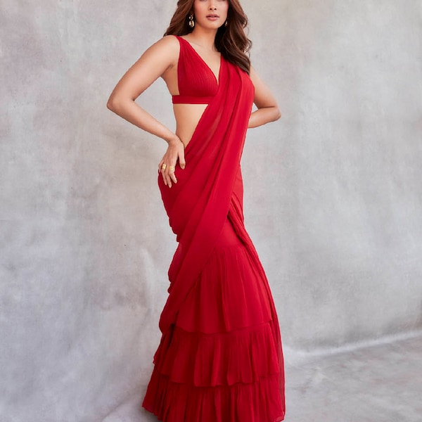 Indian actress pooja hegde  Georgette-based red sari with ruffle accents. When worn with a v-neck blouse and ruffle belt, you appear stylish