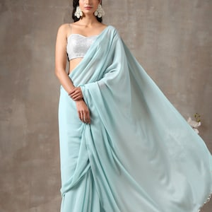 Sari azul claro con blusa blanca con estampado floral: atuendo para bodas