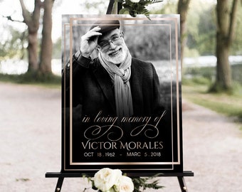Op de afbeelding: Zwart-witfoto van een man met een pet en sjaal, op een zwart en gouden ezel met de tekst "in loving memory of VICTOR MORALES OCT 18, 1962 - MARC 5, 2018".