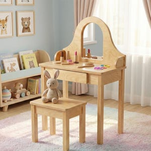 May include: A light wood children's vanity set with a matching stool. The vanity has a large arched mirror, a drawer, and is accessorized with makeup items. A stuffed bunny sits on the stool. The set is in a child's bedroom.
