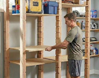 May include: A man installing a wooden storage shelf in a garage. The unfinished wooden structure has multiple shelves, with various tools and containers on the shelves. A yellow toolbox and blue container are visible.