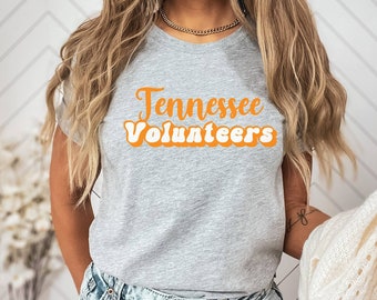 May include: A grey t-shirt with the text "Tennessee Volunteers" in orange and white letters with a retro font.