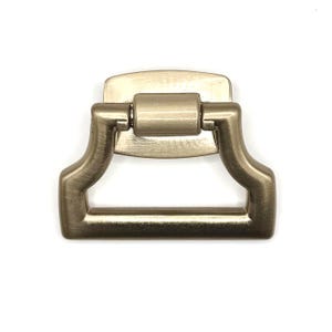 Tirador de bronce champán con placa trasera. Mide 1/2" en el centro y el asa tiene 2-1/8" de ancho.