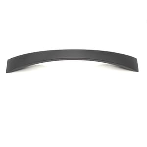 Puede incluir: Un tirador de mueble en color negro mate con un diseño arqueado y liso. El herraje presenta una forma alargada y curva con extremos planos, proporcionando una estética limpia y sencilla para muebles o armarios en el hogar u oficina.