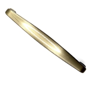Könnte beinhalten: Ein goldfarbener Schrankgriff mit gebürsteter Oberfläche. Der Griff ist ein langer, schlanker Stab mit abgerundeten Enden, der für einen einfachen Griff konzipiert ist. Die Hardware ist wahrscheinlich für Küchen- oder Badezimmerschränke.