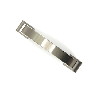 May include: A brushed nickel cabinet pull handle with a rectangular centre and square end caps. The handle is approximately 15 cm long and is set against a white background. The hardware has a modern, minimalist design.