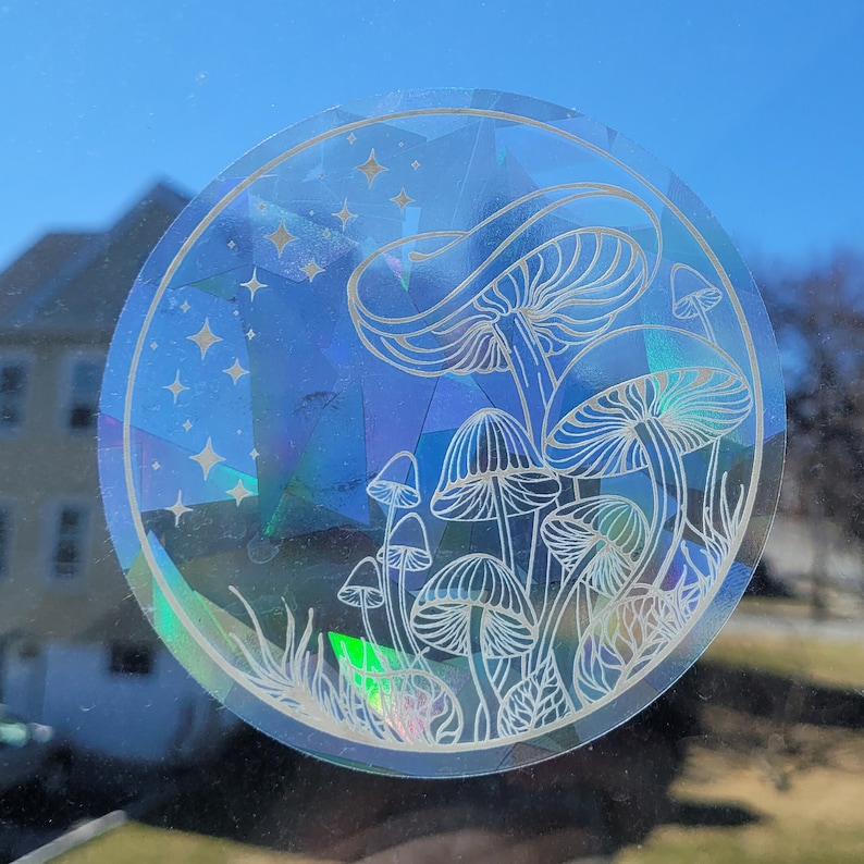 Puede incluir: Una pegatina hologr&aacute;fica con un contorno blanco de setas y estrellas sobre un fondo azul.