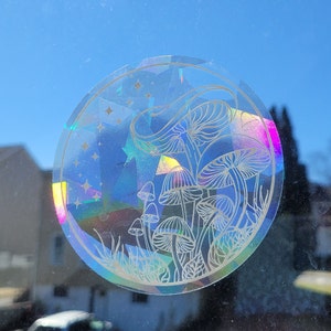 Puede incluir: Una pegatina hologr&aacute;fica con un dise&ntilde;o de setas blancas sobre un fondo azul, rosa y morado. La pegatina es redonda y tiene un acabado brillante e iridiscente.