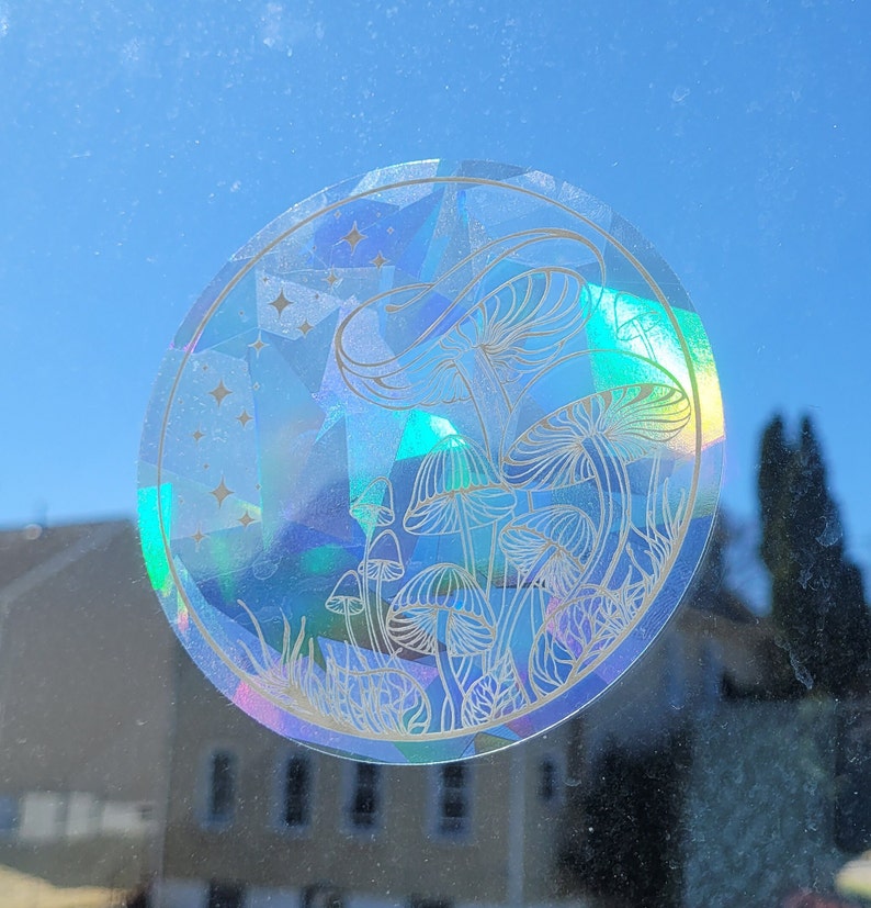 Puede incluir: Una pegatina hologr&aacute;fica con un contorno blanco de setas y estrellas sobre un fondo azul.