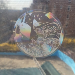 Puede incluir: Una pegatina hologr&aacute;fica con un dise&ntilde;o de setas y estrellas. La pegatina es iridiscente y tiene un efecto arco&iacute;ris.