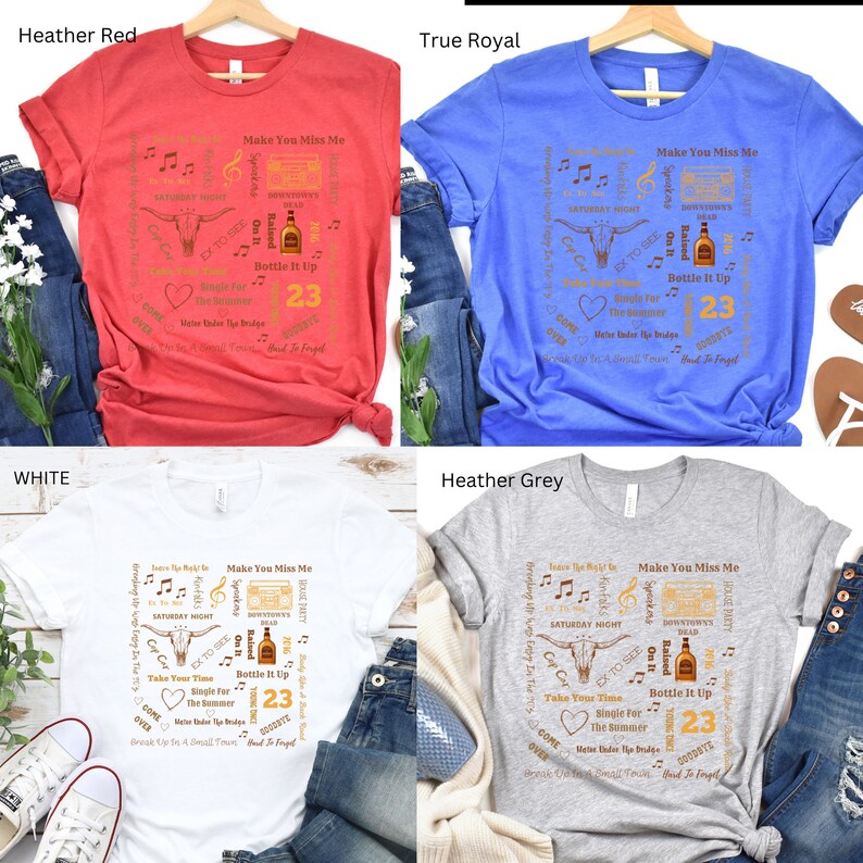 K&ouml;nnte beinhalten: Vier T-Shirts in Heather Red, True Royal, Wei&szlig; und Heather Grey. Jedes Shirt hat ein quadratisches Design mit Country-Musik-Text und -Grafiken, darunter ein Bullenkopf, Noten und die Zahl 23.