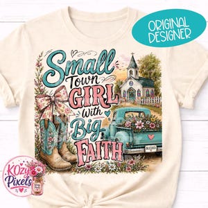 May include: Cream-colored t-shirt featuring a graphic design with the text "Small Town Girl with Big Faith." The design includes a church, a vintage truck filled with flowers, and cowboy boots. A teal oval says "Original Designer."
