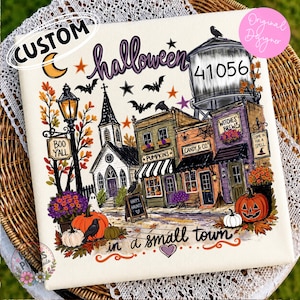 Puede incluir: Un cuadrado de tela blanca con una colorida ilustración de un pueblo de Halloween que incluye una iglesia, tiendas con letreros de Pumpkins, Candy & Co. y Witches Brew, una torre de agua con 41056, calabazas, murciélagos, un fantasma y texto.