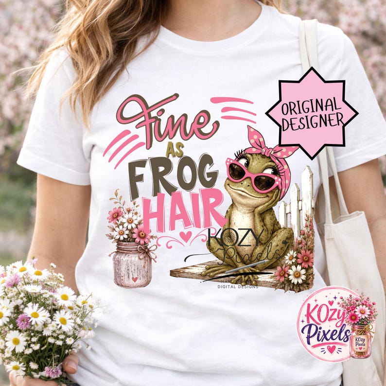 K&ouml;nnte beinhalten: Wei&szlig;es T-Shirt mit dem Aufdruck "Fine as Frog Hair". Das Design zeigt einen Frosch mit Sonnenbrille und rosa Bandana, der auf einem Holzbrett sitzt. Links ist ein Einmachglas mit Blumen.