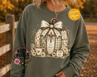 May include: An olive green crewneck sweatshirt featuring a large graphic of a pumpkin decorated with a bow, a cross, and floral accents. The design includes text that reads "I can do all things through Christ who strengthens me," "Faith over fear," and "Be still and know that I am God."