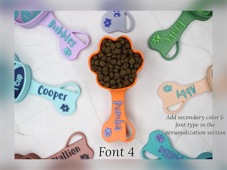 K&ouml;nnte beinhalten: Ein Set aus neun bunten, knochenf&ouml;rmigen Hundefutterl&ouml;ffeln mit personalisierten Namen. Die L&ouml;ffel sind aus Kunststoff und haben ein Pfotenabdruck-Design. Die Namen auf den L&ouml;ffeln sind Bubbles, Drako, Pumba, Cooper, 997, allion und Julie. Der Text "Font 4" wird unter den L&ouml;ffeln angezeigt.