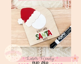 May include: A wooden Christmas countdown sign featuring a Santa hat and the text "SLEEPS UNTIL SANTA VISITS." Includes a dry-erase marker. The sign is laser-ready and an SVG file.
