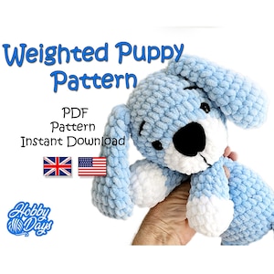 Könnte beinhalten: Ein hellblau gehäkelter Welpe mit schwarzen Augen und einer schwarzen Nase. Der Welpe hat weiße Akzente an Pfoten und Schnauze. Das Bild enthält den Text "Weighted Puppy Pattern" und "PDF Pattern Instant Download". Die Flaggen des Vereinigten Königreichs und der Vereinigten Staaten sind ebenfalls vorhanden.