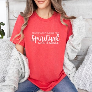 May include: A red t-shirt with the text "Temporarily Closed for Spiritual Maintenance" in white.