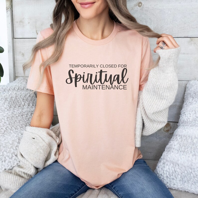 May include: A peach-colored t-shirt with the text "TEMPORARILY CLOSED FOR Spiritual MAINTENANCE" in black.
